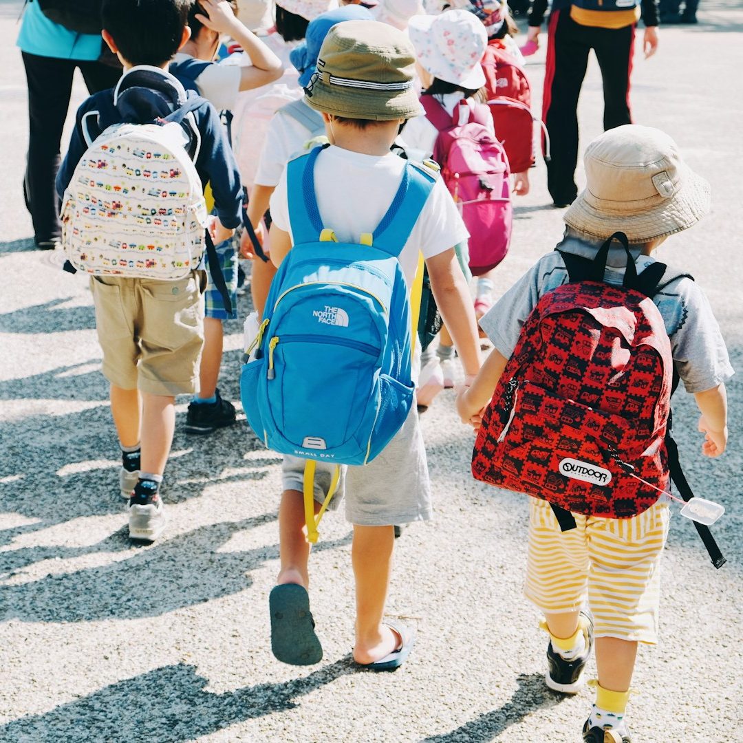 Taxi Gondal Van vor einer Schule – Kinder steigen ein